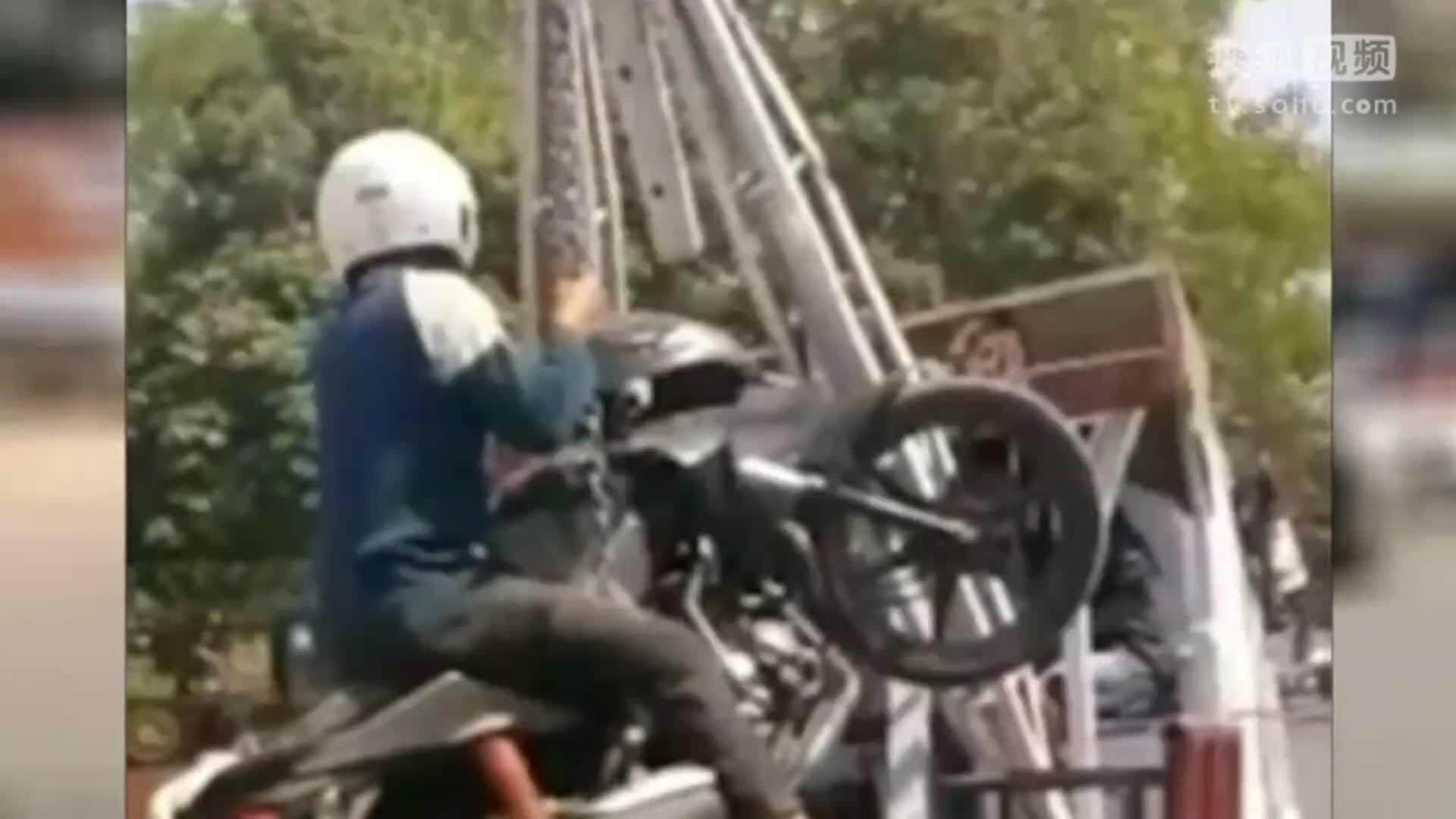 眼看摩托车被吊起 赖皮男子跳上车一并拖走