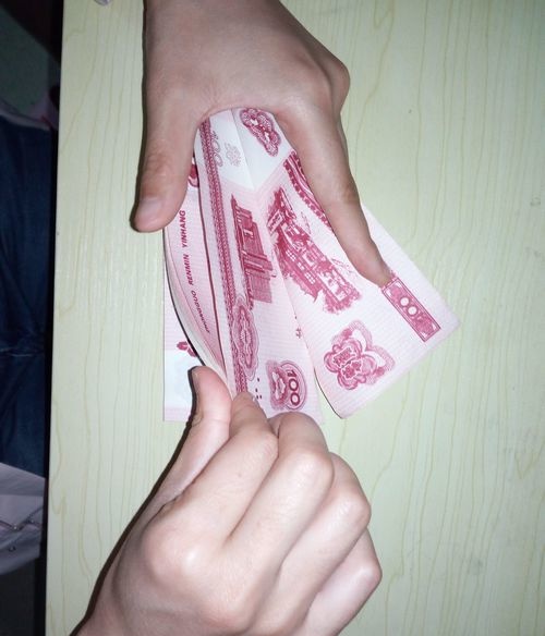 操作方法01第一步,左手小指按压在钞票左上角,如图,按压时要有一定